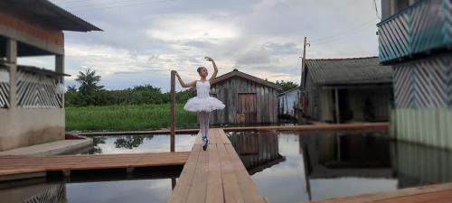 Menina faz balé sobre pontes construídas em cheia recorde do Rio Amazonas 